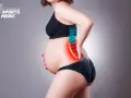 Ciężarna kobieta odczuwa ból w dolnej części pleców, co może wskazywać na rwa kulszowa w ciąży.