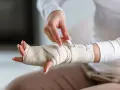 Dłoń owinięta bandażem, zapięcie na rzepy. Prezentacja bandażowania po urazie.